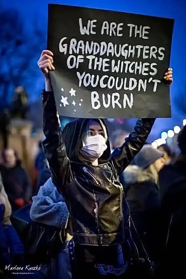 Woman holding sign that says we are the granddaughters of the witches you couldn’t burn